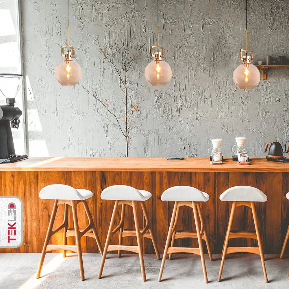 Современная подвесная лампа с янтарным стеклом и золотой отделкой, идеально подходит для гостиных в стильном интерьере.