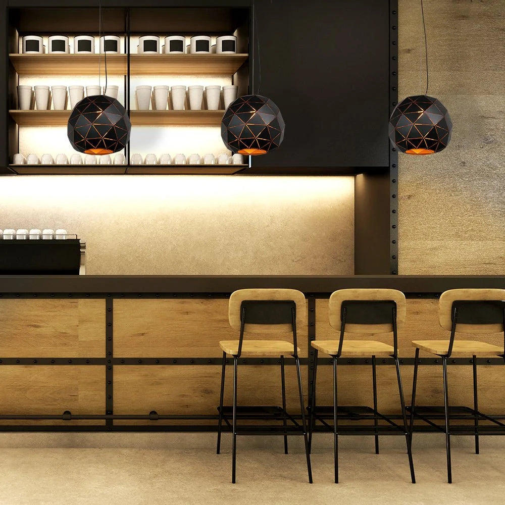 Подвесная лампа в виде большого черного металлического шара с лазерной резкой, отлично подходит для современных интерьеров.