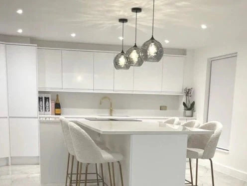 Подвесной светильник в форме дымчатого шара над обеденным столом в современном интерьере. Идеален для кухонь или гостиных.