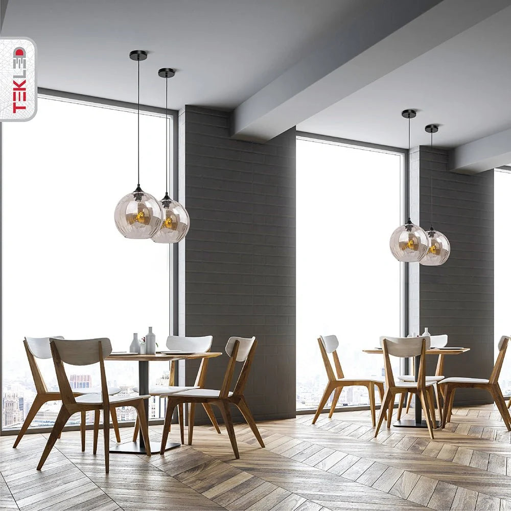 Подвесной светильник из дымчатого стекла над столом в современном интерьере, создающий уютную атмосферу.