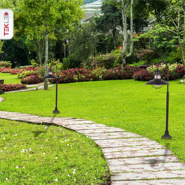 Светильник-боллард в уличной обстановке, идеален для сада в современном стиле, с черным корпусом и прозрачным стеклом.